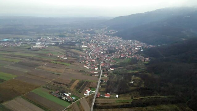 Flight above town Leskovac in southern Serbia at foothill of a mountain in cold foggy day