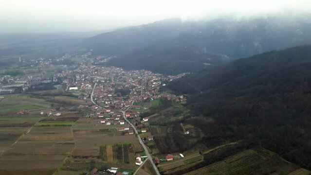 Aerial view of a town Leskovac nestled at the foothill of the mountain in southern Serbia while snow falls