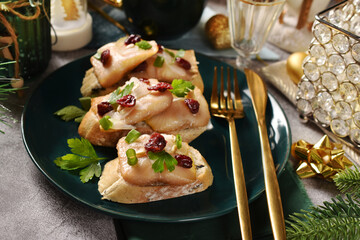Christmas table with small canapes with smoked herring fillets in oil with cranberries
