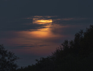 The big yellow moon shines in the sky