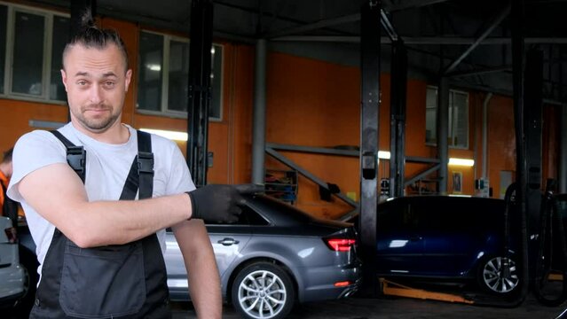 Auto mechanic points his finger to the side. Place for advertising