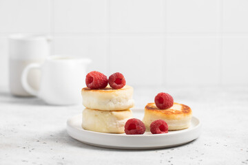 Cottage cheese fritters or syrniki served with raspberries.