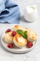 Cottage cheese fritters or syrniki served with raspberries.