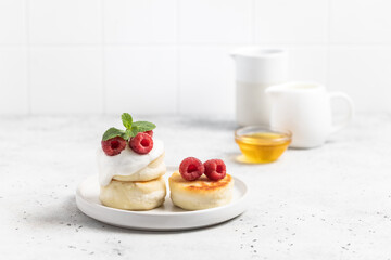 Cottage cheese fritters or syrniki served with raspberries.
