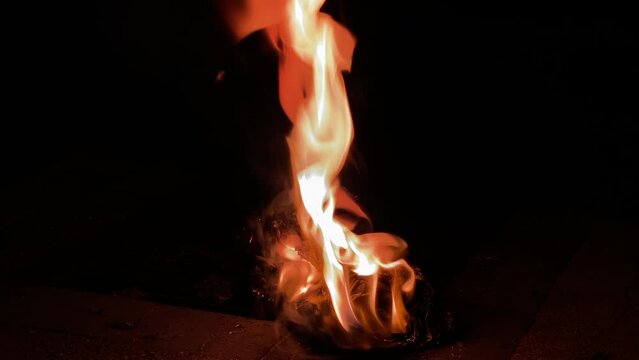 夜のキャンプ場の燃える紙の様子