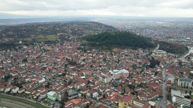 Aerial view of the Serbian town Leskovac nestled in a hilly region on a bustling, cloudy morning