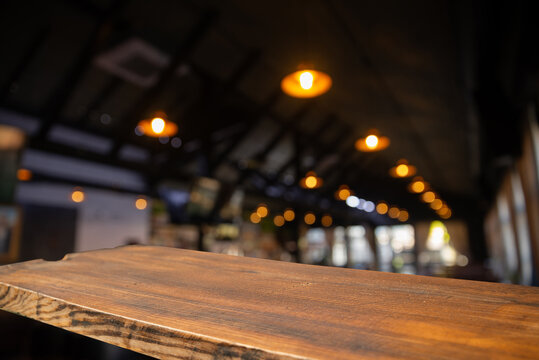 Empty wood table top and blur of cafe restaurant in dark night background. High quality photo