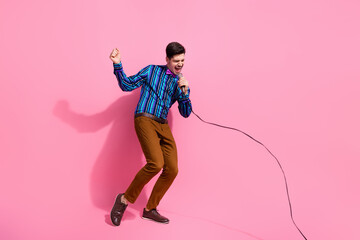 Full length photo of young talented singer started singing since he born holding microphone at concert isolated on pink color background