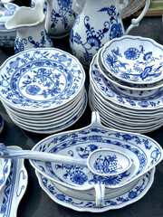 stack of blue and white porcelain plates and dishes on table