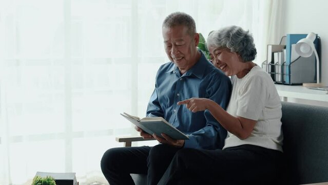 An elderly couple is spending their free time doing various activities. In a shared living room, taking care of each other in old age, the concept of living together for a retired couple.
