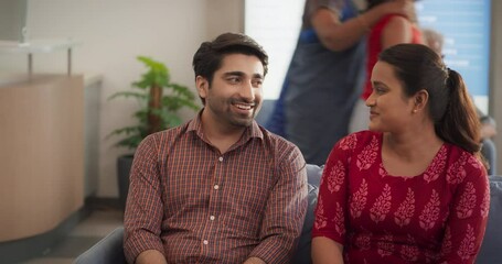 Portrait of an Indian Couple Visiting a Local City Clinic for a Health Check Up: Young Husband and Wife Talking to their Doctor, Getting Advice and Tips for a Healthy Life from Medical Specialist