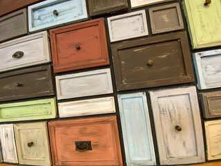 rows of drawer lids made of wood as wall decoration.