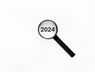 Magnifying glass focusing on year 2024 for new business linked to happy new year and merry Christmas concept