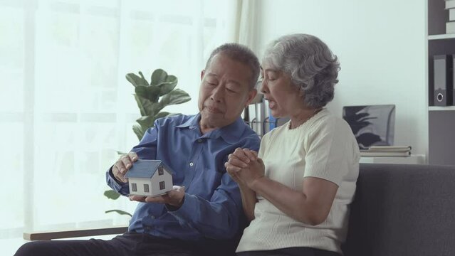An elderly couple is spending their free time doing various activities. In a shared living room, taking care of each other in old age, the concept of living together for a retired couple.