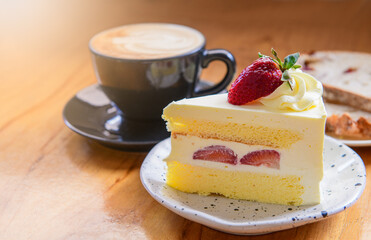 Strawberry cake, vanilla sponge cake with cream cheese and fresh strawberries with hot coffee.
