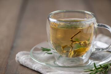hot tea on wood table. Transparent cup of freshly brewed tea on wood table