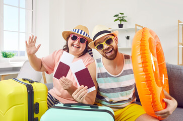Happy family couple ready for summer vacation. Portrait funny joyful husband and wife sitting on...