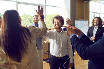 Happy colleagues man and woman giving high five at meeting at office, celebrating success, making a...