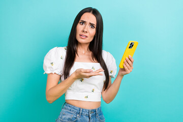 Photo of confused young blogging disappointed woman showing hand smartphone apple device wtf email spam isolated on blue color background