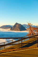 Mountain Peak San Salvatore Above Cloudscape and Mountain Road with Sunlight and Clear Sky in Lugano, Ticino in Switzerland.