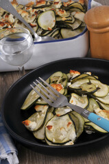 Assiette de gratin de courgettes maison avec une fourchette en gros plan.