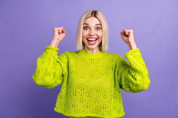 Photo of cute lucky lady wear green pullover rising fists screaming yeah isolated purple color...