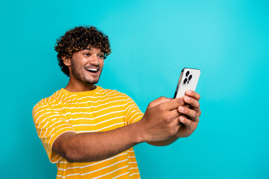 Photo of handsome guy device instagram twitter facebook telegram dressed stylish striped yellow outfit isolated on cyan color background