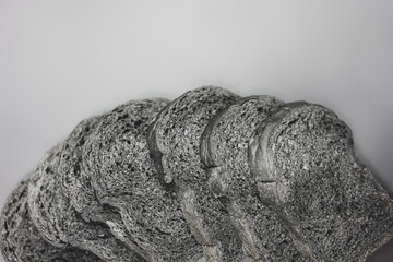 Black charcoal sliced bread over black backdrop, top view, Healthy eating concept.