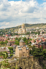 Fototapeta na wymiar View of Holy Trinity Cathedral of Tbilisi and Metekhi, with parts of Tbilisi's Old Town seen on the horizon.