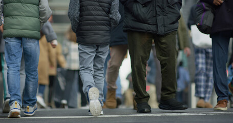 Crowd of people walking street low angle legs feet in city