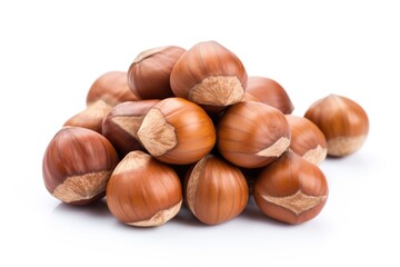 Fototapeta premium A pile of hazel nuts on a white surface.