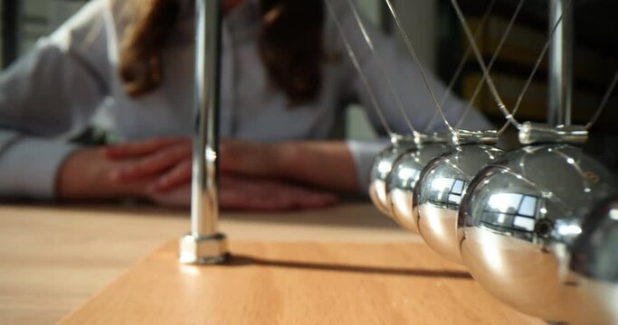 Business people from Newton Cradle introduced concept of ball explaining cause and effect