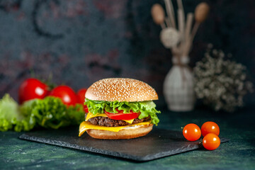 delicious homemade burger of beef, cheese and vegetables on an table. Fat unhealthy food close-up,...