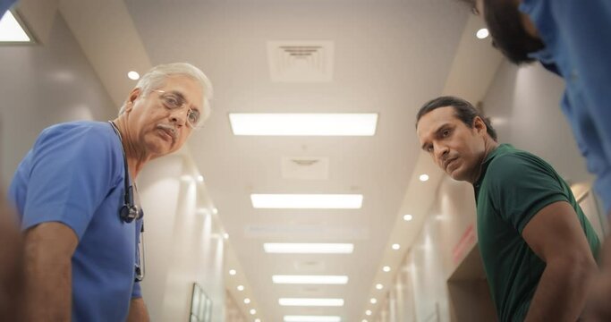 Slow Motion POV of a Patient Being Transported on a Stretcher Through a Hospital Corridor by a Group of Medical Specialists. Health Clinic Receiving an Emergency Case for Intensive Care Unit