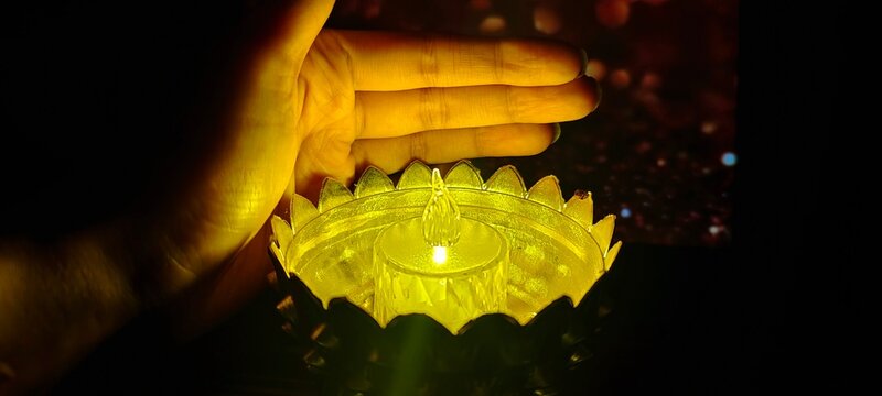 Woman holding lit diya lamp in hands, closeup. Diwali celebration