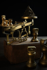 Obraz na płótnie Canvas Black caviar on the scales. Vintage brass scales are out of focus. An exquisite and expensive snack. Natural omega. Dark background. Vertical photo.