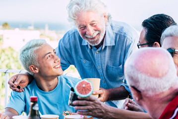 Mixed generations family enjoy together food and celebration outdoor. Young teenager boy and...