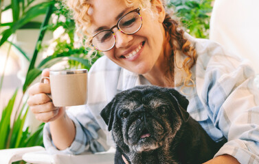 Love people and dog animal concept with happy adult caucasian woman and black old pug hugging and...