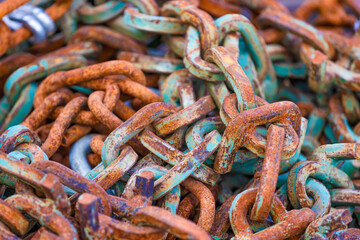 Close up of a pile of chain links corroding.