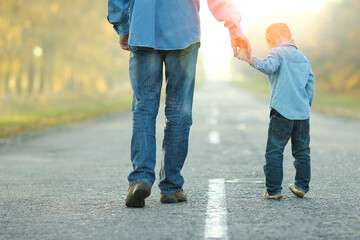 A Happy parent with child are walking along the road in the park on nature travel