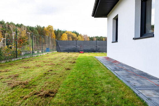 Scarifying the lawn before the winter season using an electric scarifier.
