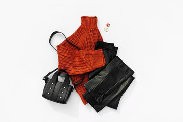 Fashion autumnal outfit. Knitted brown sweater with  leather pants and handbag. Women's warm...