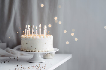 White and gold birthday cake with candles on the white table, minimalistic style. Generative AI