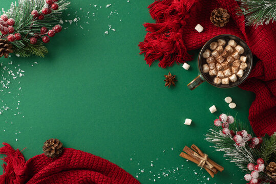 Experience the magic of winter with a top-view image of a delightful hot chocolate with marshmallow, anise, cinnamon sticks and seasonal adornments on a green backdrop with text space