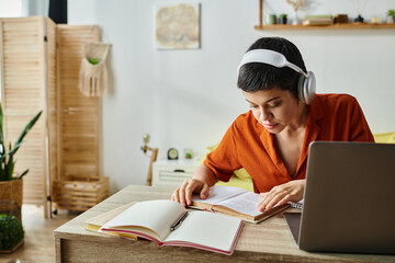 concentrated short haired woman with headphones studying from home looking at textbook, education