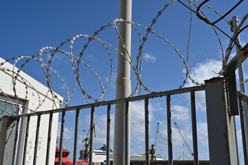 The barbed wire on top of the fence enclosing the passenger dock. The fence protects against...