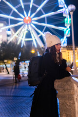 Girl staring blankly at a Ferris wheel in the background