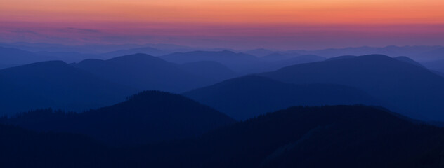 Panorama Silhouettes of Carpathian mountains in a natural blue-red gradient. Panorama of the Carpathian Mountains at dusk with silhouettes of ridges and peaks. Gorgany, Carpathians, Ukraine. - obrazy, fototapety, plakaty