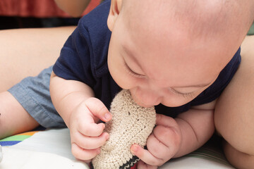 4 month old baby eating his knitted slipper