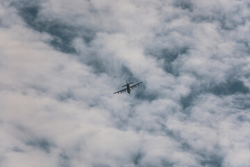 Fototapeta na wymiar C-130 flying through clouds